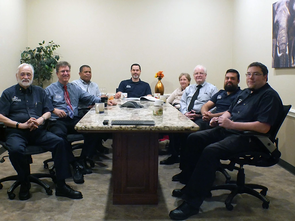 Group of people seated around a conference table in a meeting room